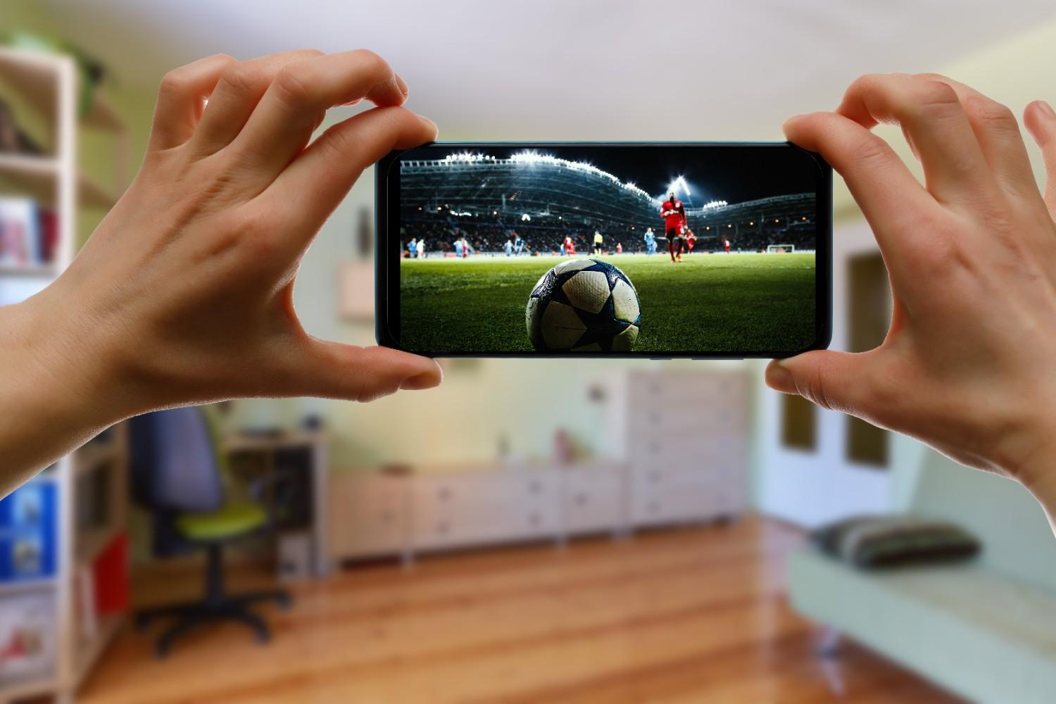 watching-football-game-home-via-smartphone-broadcasting-soccer-from-stadium